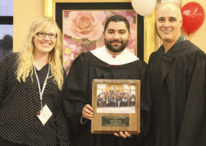 Zachary Gonzalez, NHI director of Collegiate Affairs, presents a gift to two Saint Leo University representatives: Nicole Lesko, Associate Director of Events and Campus Visits, and John LaRosa, Assistant Vice President, Campus Enrollment