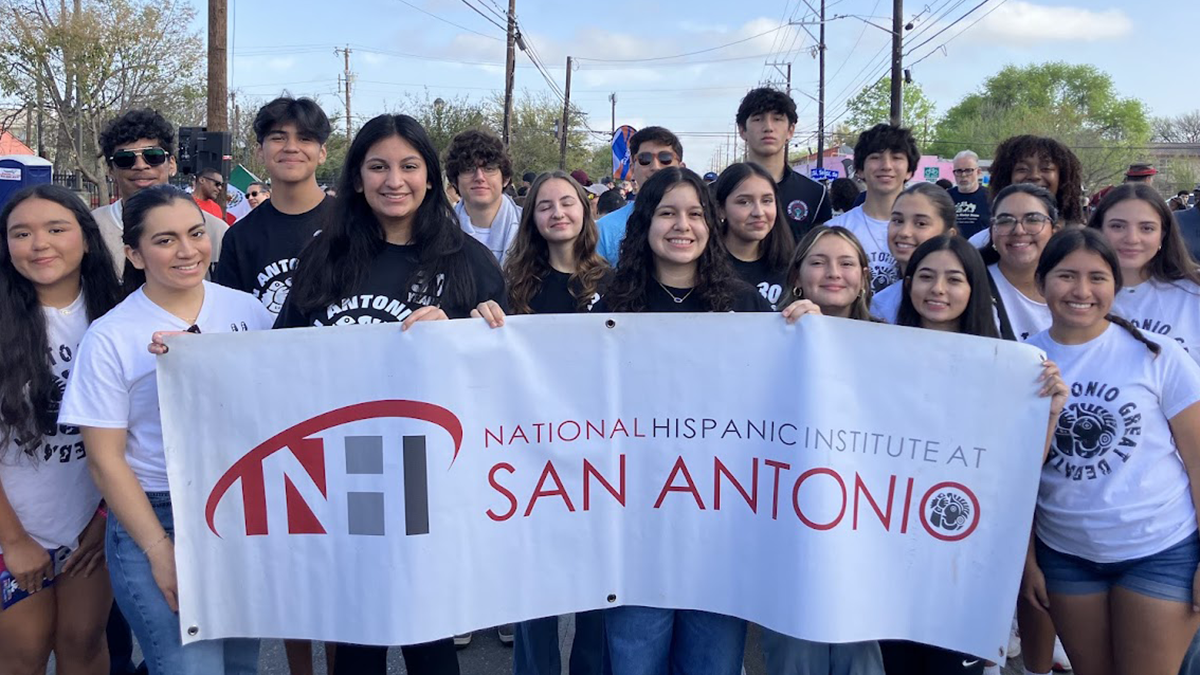 Group of NHI@SA students holding banner